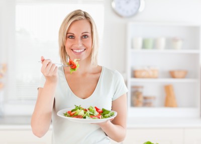 Woman eating a healthy meal of fresh vegetables and salad.